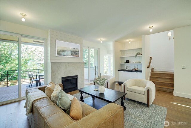 9208 11th Ave NW, Seattle, WA 98117 - living area featuring a fireplace, stairs, wood finished floors, and healthy amount of natural light