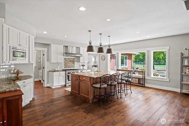 13228 202nd Ave SE, Issaquah, WA 98027 - kitchen featuring stainless steel appliances, wall chimney exhaust hood, decorative backsplash, dark wood-style flooring, and white cabinetry