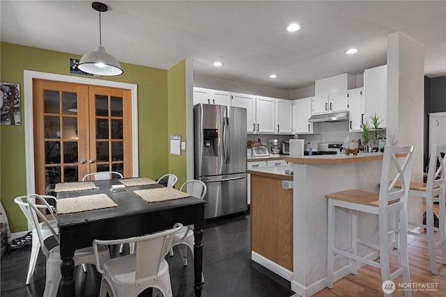 5850 Rest Pl NE, Bremerton, WA 98311 - kitchen with stainless steel fridge, a peninsula, under cabinet range hood, light countertops, and pendant lighting