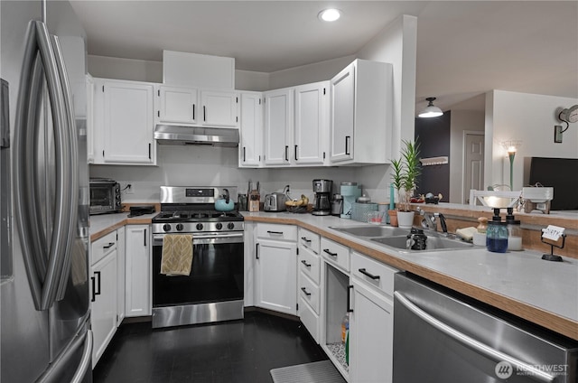 5850 Rest Pl NE, Bremerton, WA 98311 - kitchen with appliances with stainless steel finishes, under cabinet range hood, light countertops, white cabinetry, and recessed lighting