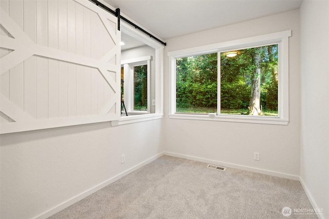 14855 Phelps Rd NE, Bainbridge Island, WA 98110 - carpeted empty room with baseboards and a barn door