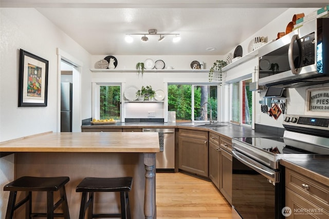 14855 Phelps Rd NE, Bainbridge Island, WA 98110 - kitchen featuring stainless steel appliances, wooden counters, a kitchen breakfast bar, and open shelves