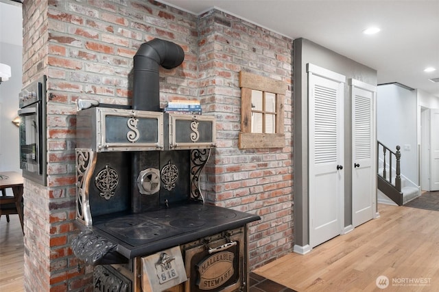 14855 Phelps Rd NE, Bainbridge Island, WA 98110 - detailed view of wood finished floors, brick wall, a wood stove, and recessed lighting