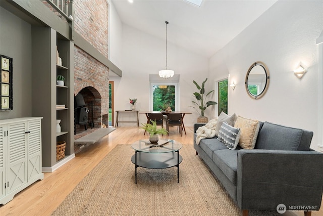 14855 Phelps Rd NE, Bainbridge Island, WA 98110 - living room featuring light wood-type flooring, a wood stove, and high vaulted ceiling