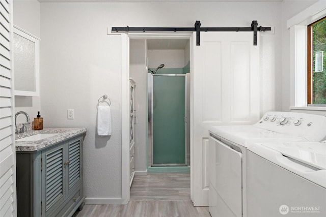 14855 Phelps Rd NE, Bainbridge Island, WA 98110 - washroom featuring light wood-style floors, independent washer and dryer, and a barn door