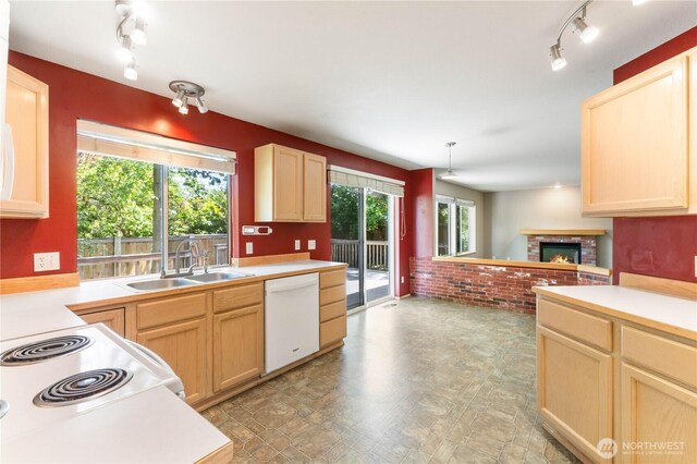 3035 Carbon Ridge St, Enumclaw, WA 98022 - kitchen featuring white appliances, rail lighting, a brick fireplace, and light brown cabinetry