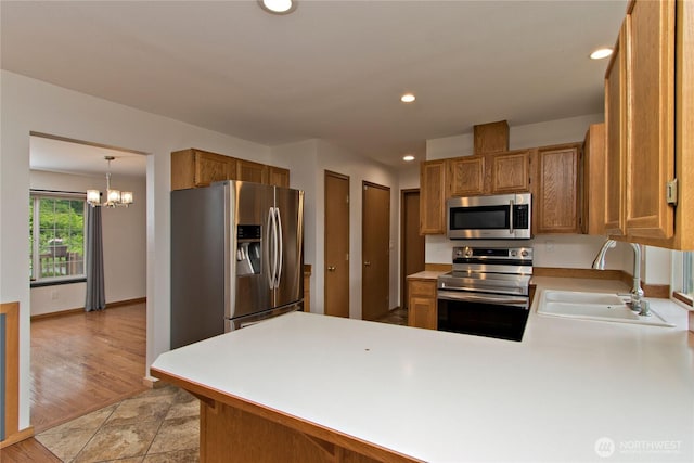 408 Cross Creek Ct, South Prairie, WA 98385 - kitchen featuring stainless steel appliances, a peninsula, light countertops, recessed lighting, and a chandelier