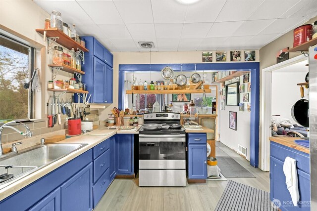 1501 Lakeway Dr, Bellingham, WA 98225 - kitchen featuring stainless steel electric range oven, blue cabinetry, open shelves, and light wood-type flooring