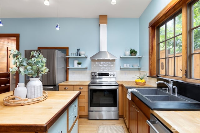 832 Willow St, Port Townsend, WA 98368 - kitchen featuring butcher block countertops, stainless steel appliances, wall chimney exhaust hood, open shelves, and light wood-style floors