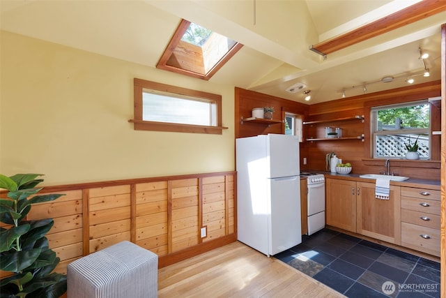 832 Willow St, Port Townsend, WA 98368 - kitchen with white appliances, lofted ceiling, open shelves, wooden walls, and a skylight