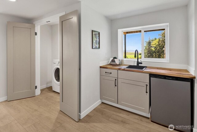 16071 Colony Rd, Bow, WA 98232 - kitchen featuring stainless steel dishwasher, butcher block countertops, washer / clothes dryer, and light wood-style floors