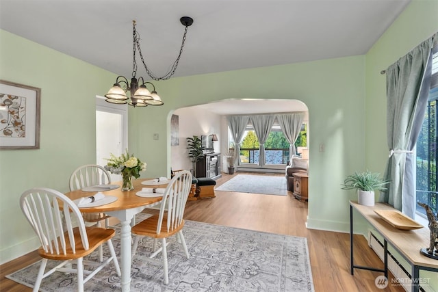 2319 Gale Pl, Everett, WA 98203 - dining room featuring arched walkways, wood finished floors, and a baseboard heating unit
