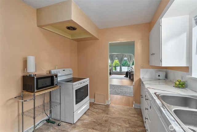 2319 Gale Pl, Everett, WA 98203 - kitchen with white electric range oven, stainless steel microwave, white cabinets, and light countertops