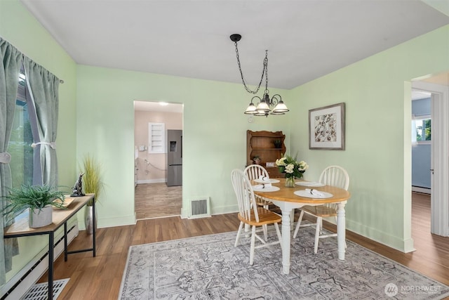 2319 Gale Pl, Everett, WA 98203 - dining room featuring wood finished floors, a baseboard heating unit, and a chandelier