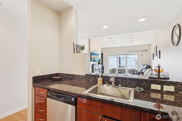 1 Broadway Unit 721, Tacoma, WA 98402 - kitchen with stainless steel dishwasher, light wood-style flooring, dark stone countertops, and track lighting