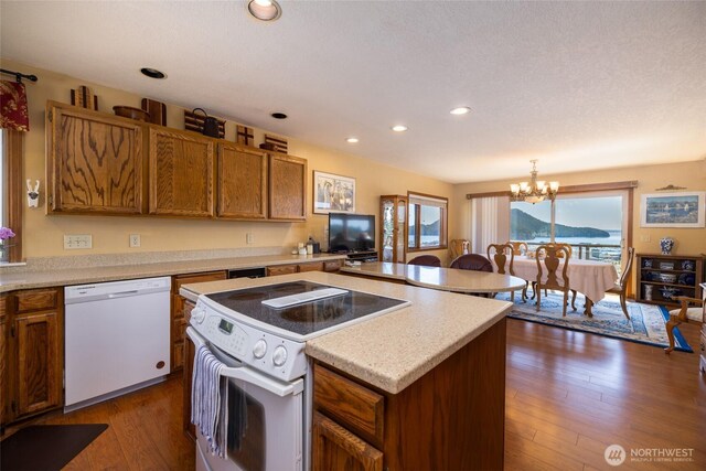 1807 Bradley Dr, Anacortes, WA 98221 - kitchen with white appliances, a chandelier, brown cabinetry, light countertops, and a center island