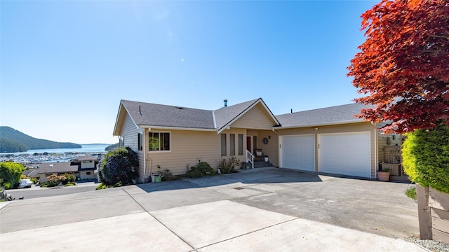 1807 Bradley Dr, Anacortes, WA 98221 - ranch-style home featuring a garage, driveway, a mountain view, and a shingled roof