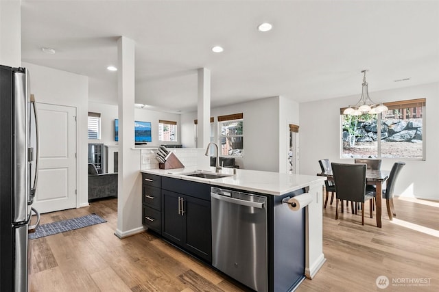 21552 SE 275th Ct, Maple Valley, WA 98038 - kitchen featuring appliances with stainless steel finishes, a chandelier, light wood finished floors, recessed lighting, and dark cabinets