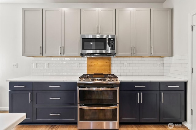 21552 SE 275th Ct, Maple Valley, WA 98038 - kitchen with appliances with stainless steel finishes, light countertops, decorative backsplash, and gray cabinetry