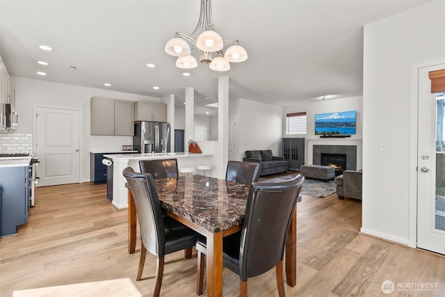 21552 SE 275th Ct, Maple Valley, WA 98038 - dining area featuring a chandelier, light wood-style flooring, a tile fireplace, and recessed lighting