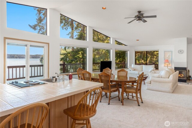 160 Wildwood Shrs, Brinnon, WA 98320 - dining room with a water view, a ceiling fan, light colored carpet, and high vaulted ceiling