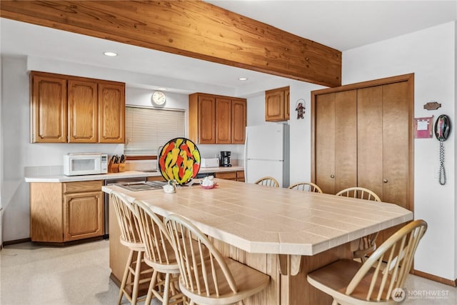 160 Wildwood Shrs, Brinnon, WA 98320 - kitchen with white appliances, a kitchen bar, brown cabinetry, recessed lighting, and a kitchen island