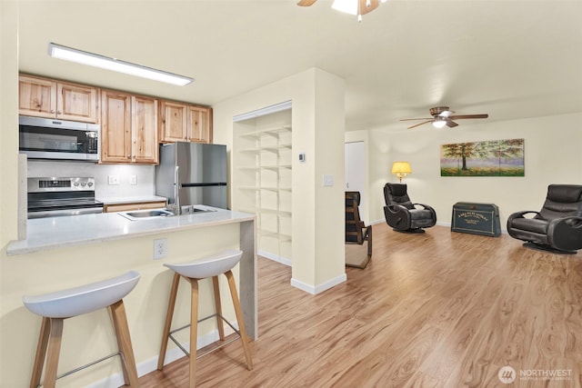 4617 Grandview Dr W Unit D, Tacoma, WA 98466 - kitchen with appliances with stainless steel finishes, ceiling fan, a breakfast bar, and light wood finished floors