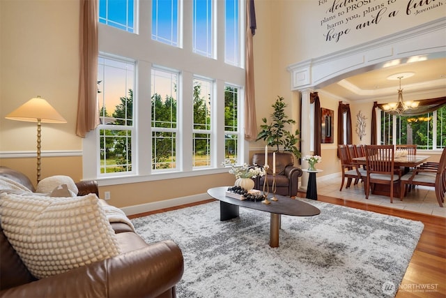 24702 64th Ave E, Graham, WA 98338 - living room with a chandelier, healthy amount of natural light, arched walkways, a high ceiling, and crown molding