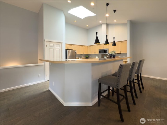 4196 248th Ct SE Unit 62, Sammamish, WA 98029 - kitchen with stainless steel appliances, dark wood-style flooring, a high ceiling, light brown cabinets, and a kitchen breakfast bar