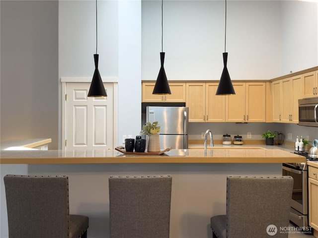 4196 248th Ct SE Unit 62, Sammamish, WA 98029 - kitchen with appliances with stainless steel finishes, light countertops, a breakfast bar, pendant lighting, and a towering ceiling
