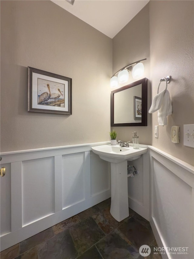 4196 248th Ct SE Unit 62, Sammamish, WA 98029 - bathroom featuring stone finish floors, a decorative wall, and wainscoting