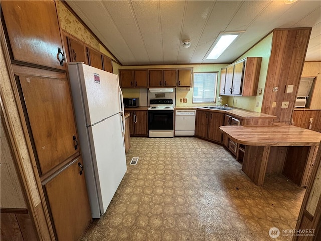 31600 126th Ave SE Unit 100, Auburn, WA 98092 - kitchen featuring white appliances, light floors, under cabinet range hood, wooden walls, and a peninsula