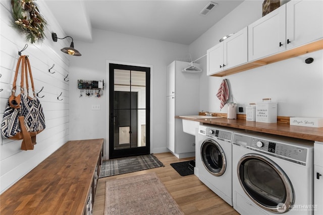485 Hidden Ln, Chelan, WA 98816 - laundry room featuring washing machine and clothes dryer, cabinet space, and light wood-style floors