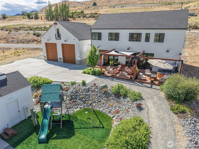 485 Hidden Ln, Chelan, WA 98816 - back of property featuring a playground, an outdoor structure, a detached garage, a lawn, and a deck with mountain view