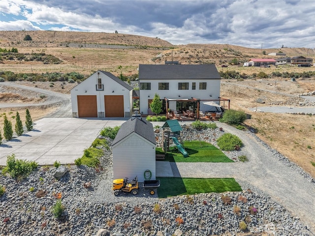 485 Hidden Ln, Chelan, WA 98816 - view of front facade featuring a detached garage, a playground, an outdoor structure, and a mountain view