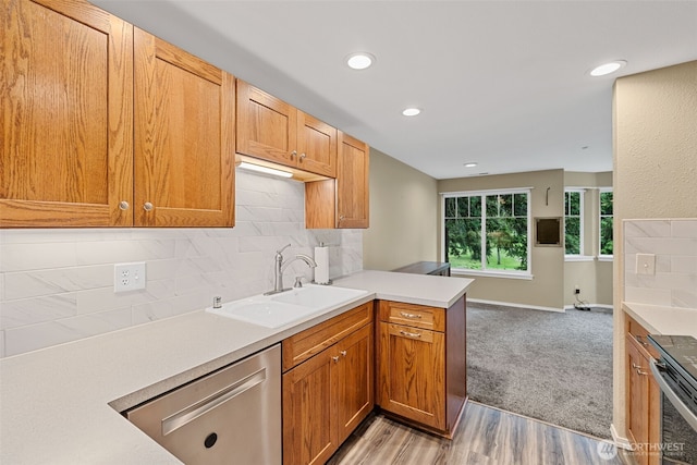 4714 Fairwood Blvd NE Unit 1704, Tacoma, WA 98422 - kitchen featuring appliances with stainless steel finishes, a peninsula, light countertops, decorative backsplash, and light wood-style floors