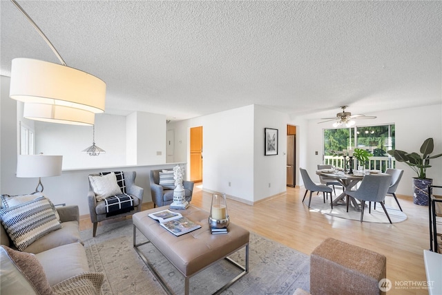 33513 35th Ave SW, Federal Way, WA 98023 - living room featuring a textured ceiling, light wood-style flooring, and a ceiling fan