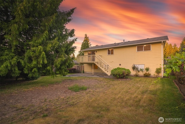 33513 35th Ave SW, Federal Way, WA 98023 - back of property at dusk with stairway, a lawn, a wooden deck, and a patio
