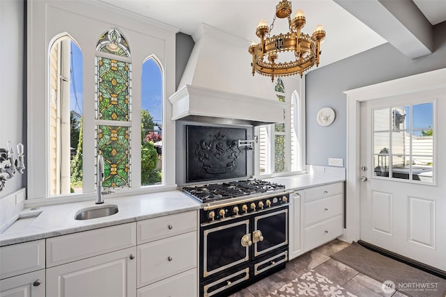 4410 N 45th St, Tacoma, WA 98407 - kitchen with double oven range, custom exhaust hood, a chandelier, and white cabinetry