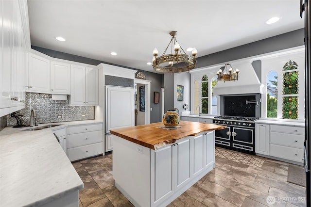 4410 N 45th St, Tacoma, WA 98407 - kitchen with high quality appliances, wood counters, a chandelier, custom range hood, and healthy amount of natural light