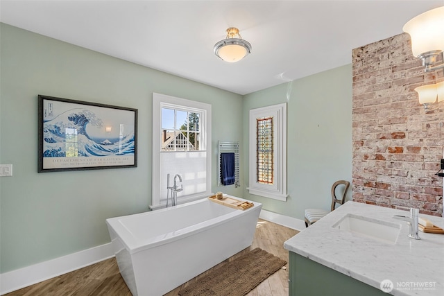 4410 N 45th St, Tacoma, WA 98407 - bathroom featuring wood finished floors, vanity, a freestanding bath, and brick wall