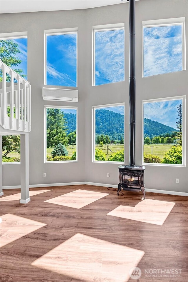 25321 133rd Ave NE, Arlington, WA 98223 - unfurnished living room featuring a wood stove, wood finished floors, healthy amount of natural light, and a towering ceiling