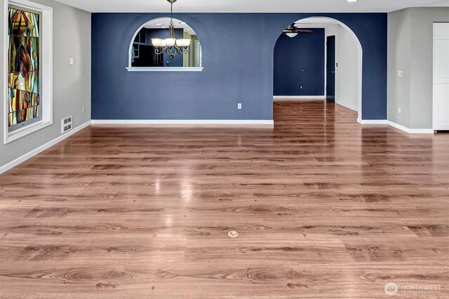 25321 133rd Ave NE, Arlington, WA 98223 - unfurnished room featuring arched walkways, a chandelier, wood finished floors, and ceiling fan