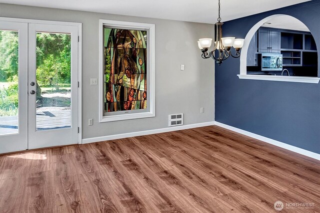 25321 133rd Ave NE, Arlington, WA 98223 - unfurnished dining area with a chandelier, wood finished floors, arched walkways, and french doors