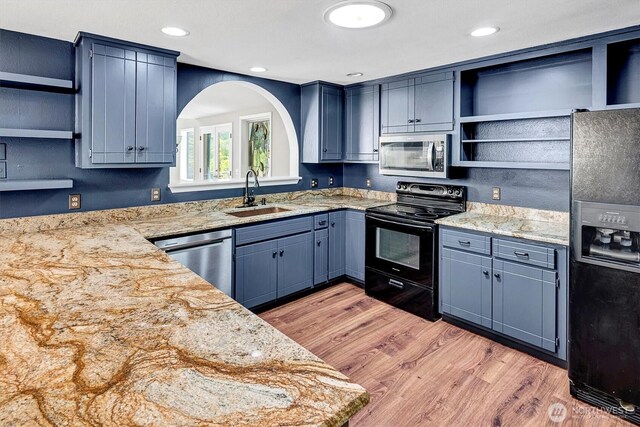 25321 133rd Ave NE, Arlington, WA 98223 - kitchen with stainless steel appliances, open shelves, arched walkways, light wood finished floors, and blue cabinets