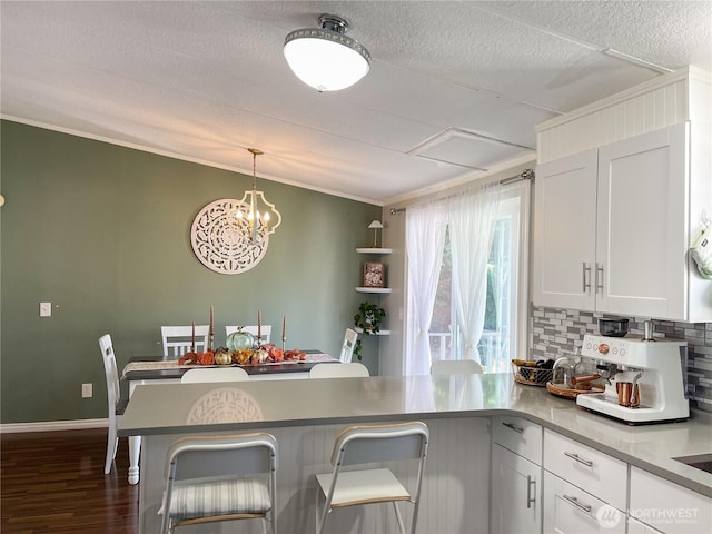 15410 SE 272nd St Unit 71, Kent, WA 98030 - kitchen featuring a peninsula, tasteful backsplash, white cabinetry, dark wood-style floors, and ornamental molding
