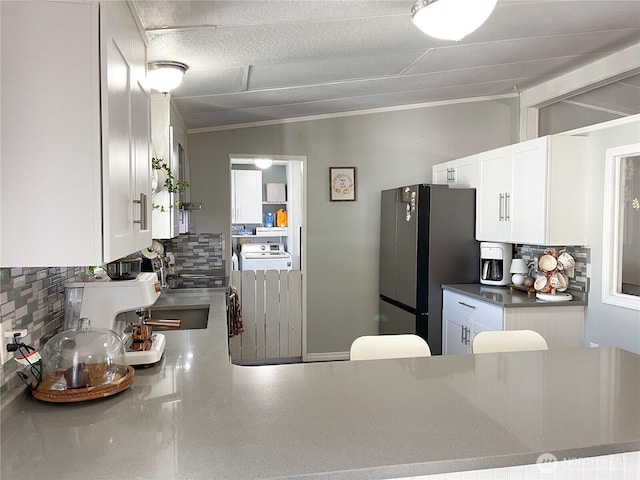 15410 SE 272nd St Unit 71, Kent, WA 98030 - kitchen featuring freestanding refrigerator, decorative backsplash, ornamental molding, white cabinetry, and stove