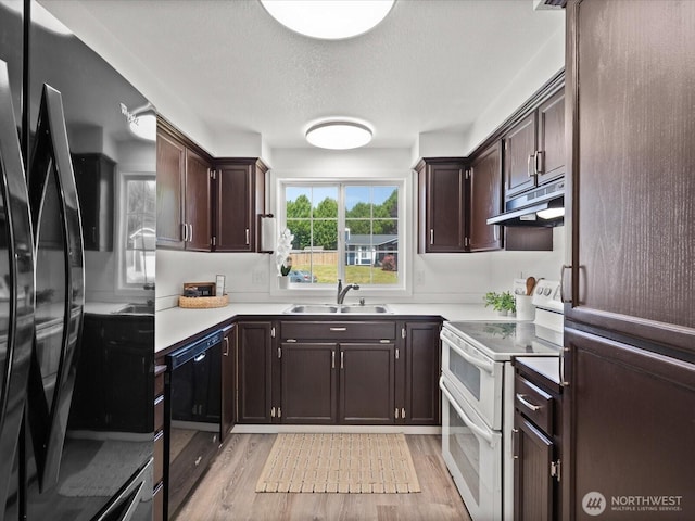 7102 Church Creek Cir NW, Stanwood, WA 98292 - kitchen with range with two ovens, under cabinet range hood, black dishwasher, fridge, and light wood-style floors