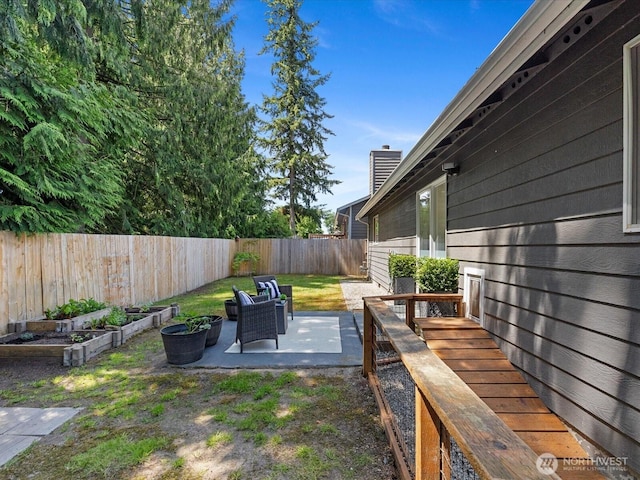 7102 Church Creek Cir NW, Stanwood, WA 98292 - fenced backyard with a vegetable garden and a patio