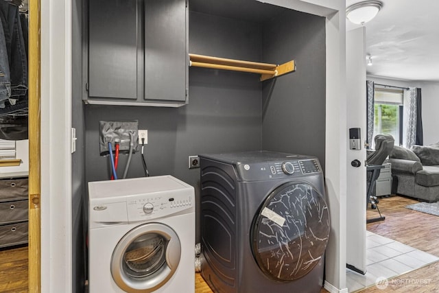 1717 14th Ave SE, Olympia, WA 98501 - laundry room featuring washing machine and clothes dryer, cabinet space, and wood finished floors